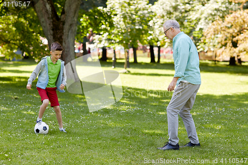 Image of old man and boy playing football at summer park