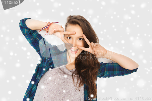 Image of happy smiling teenage girl showing peace sign