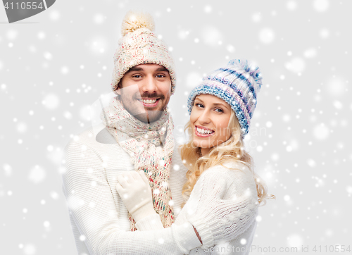 Image of smiling couple in winter clothes hugging