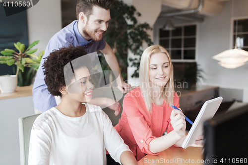 Image of happy creative team with computer in office