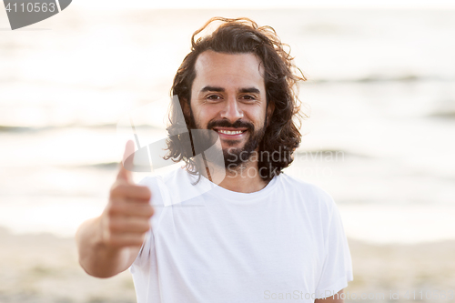 Image of happy smiling man with beard on beach