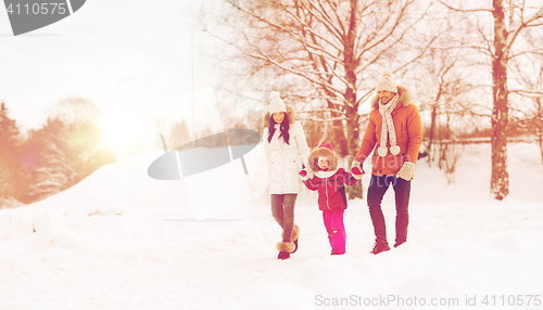 Image of happy family in winter clothes walking outdoors