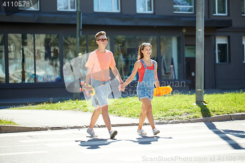 Image of teenage couple with skateboards on city street