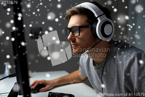 Image of man in headset playing computer video game at home