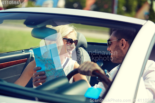 Image of happy man and woman with map in cabriolet car