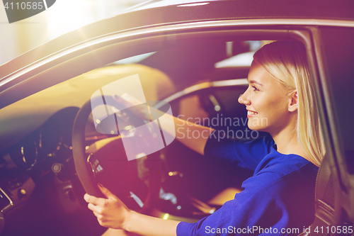 Image of happy woman inside car in auto show or salon