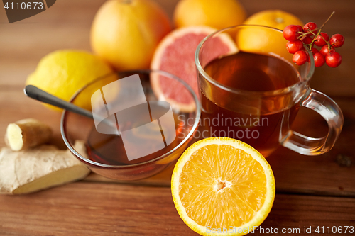 Image of tea with honey, orange and rowanberry on wood