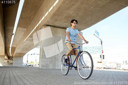 Image of young hipster man riding fixed gear bike