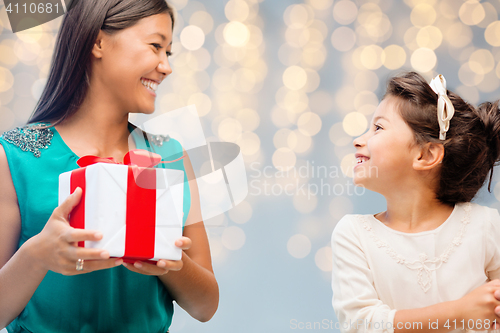 Image of happy mother giving birthday present to her child