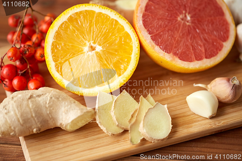 Image of citrus, ginger, garlic and rowanberry on wood
