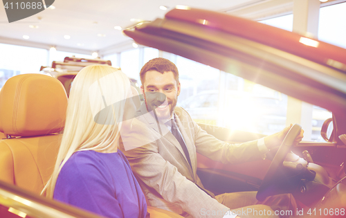 Image of happy couple buying car in auto show or salon