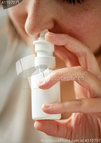 Image of close up of sick woman using nasal spray