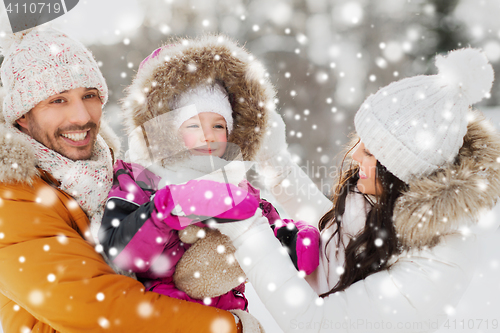 Image of happy family with child in winter clothes outdoors