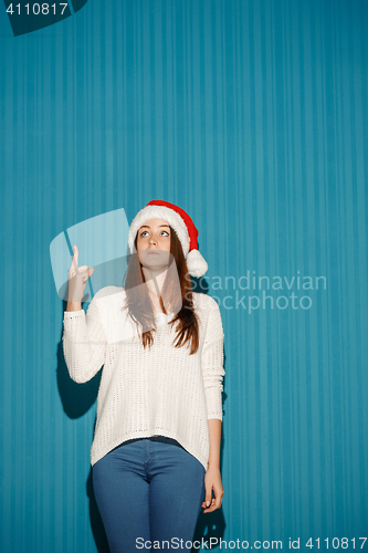 Image of Surprised christmas girl wearing a santa hat
