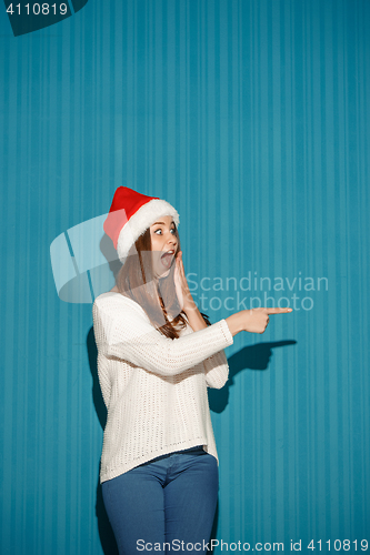 Image of Surprised christmas girl wearing a santa hat