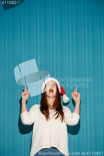 Image of Surprised christmas girl wearing a santa hat