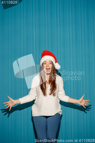 Image of Surprised christmas girl wearing a santa hat
