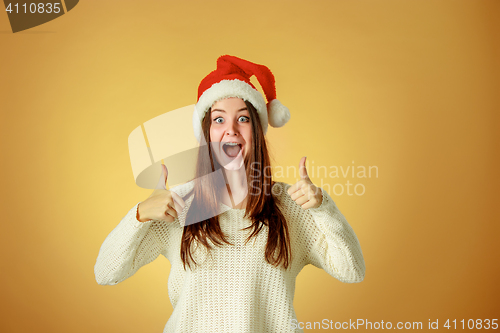 Image of Surprised christmas girl wearing a santa hat