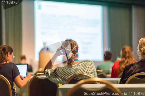 Image of Audience in lecture hall participating at business conference.