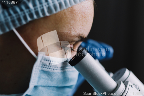 Image of Female scientist looking at microscope