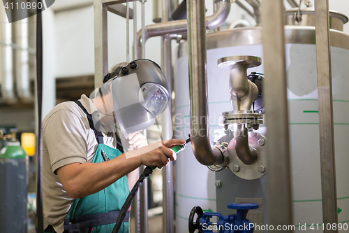 Image of Industrial worker welding in metal factory.