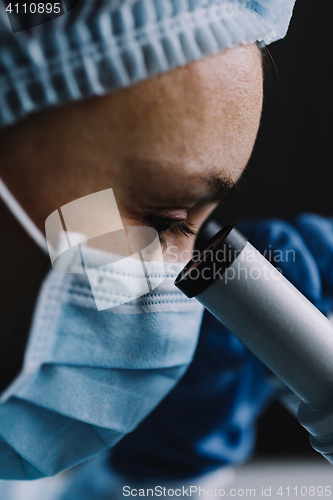 Image of Female scientist looking at microscope