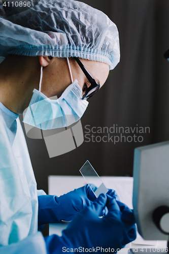 Image of Female scientist arranging microscope glasses in box