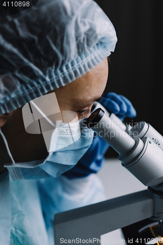 Image of Female scientist looking at microscope