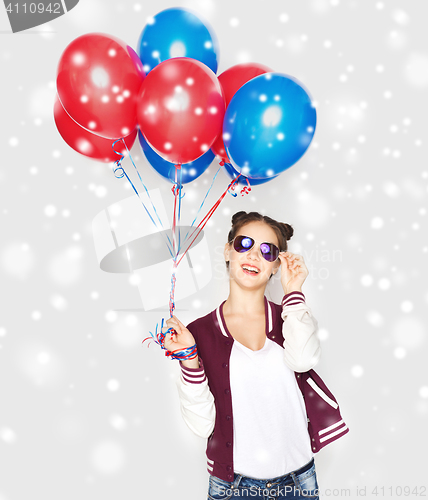 Image of happy teenage girl with helium balloons over snow