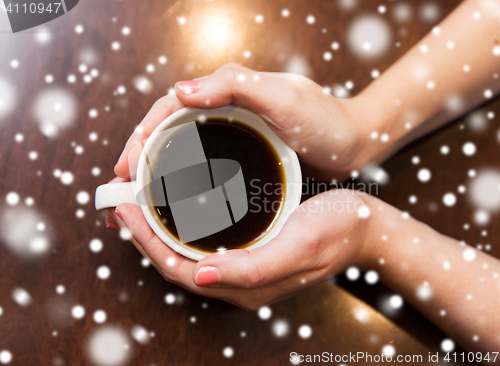 Image of close up of woman holding hot black coffee cup