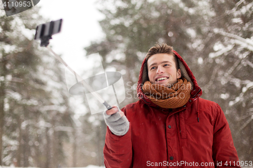 Image of happy man taking selfie by smartphone in winter