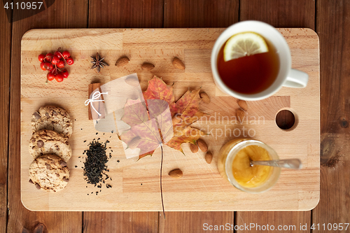 Image of cup of tea with lemon, honey and cookies on board