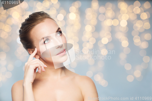 Image of beautiful young woman touching her face