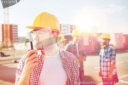 Image of group of builders in hardhats with radio