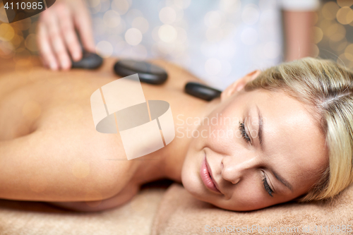 Image of close up of woman having hot stone massage in spa