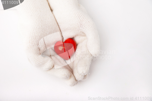 Image of Woman hands in white gloves holding heart symbol