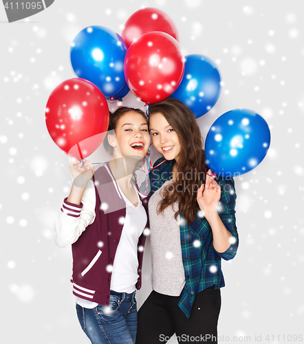 Image of happy teenage girls with helium balloons over snow