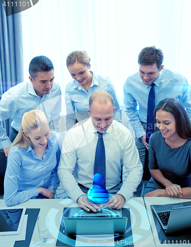 Image of smiling business people with laptop in office