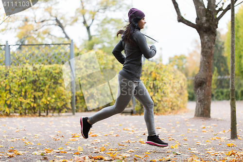 Image of close up of young woman running in autumn park