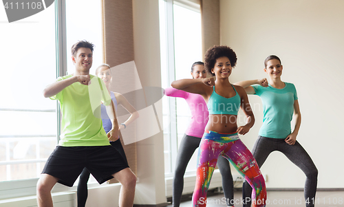 Image of group of smiling people dancing in gym or studio