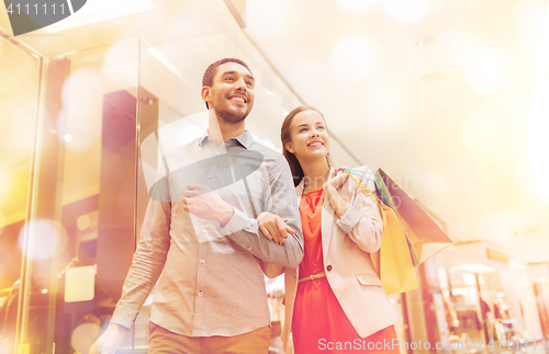 Image of happy young couple with shopping bags in mall