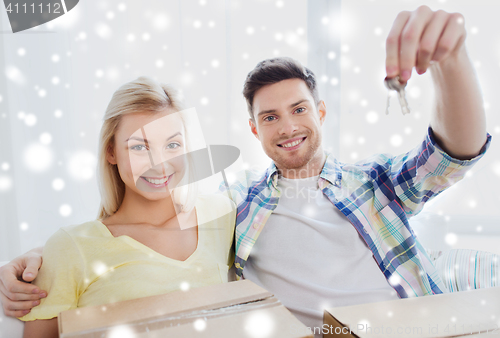 Image of happy couple with key and boxes moving to new home