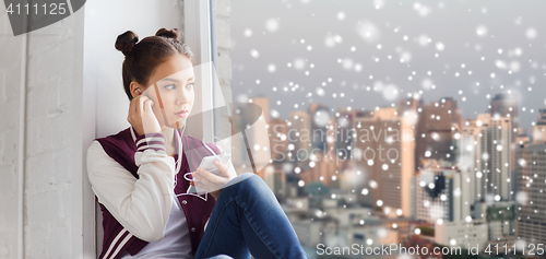 Image of teenage girl with smartphone and earphones