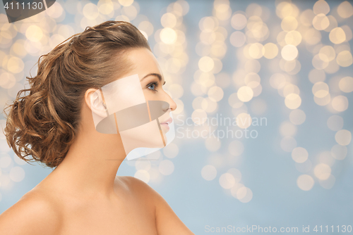 Image of beautiful young woman face over lights background