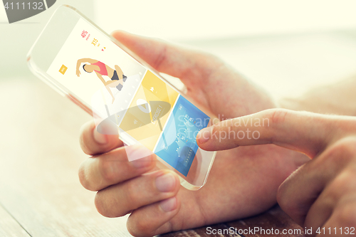 Image of close up of hand with sport app on smartphone