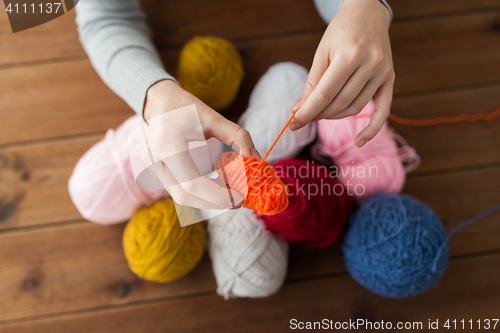 Image of woman pulling yarn up into ball