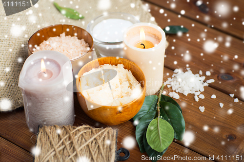 Image of natural body scrub and candles on wood