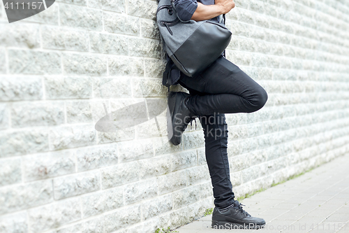 Image of close up of man with backpack standing at wall