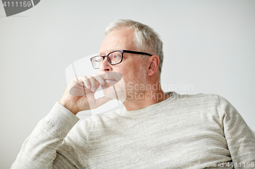 Image of close up of senior man in glasses thinking