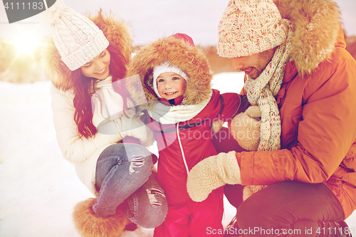 Image of happy family with child in winter clothes outdoors